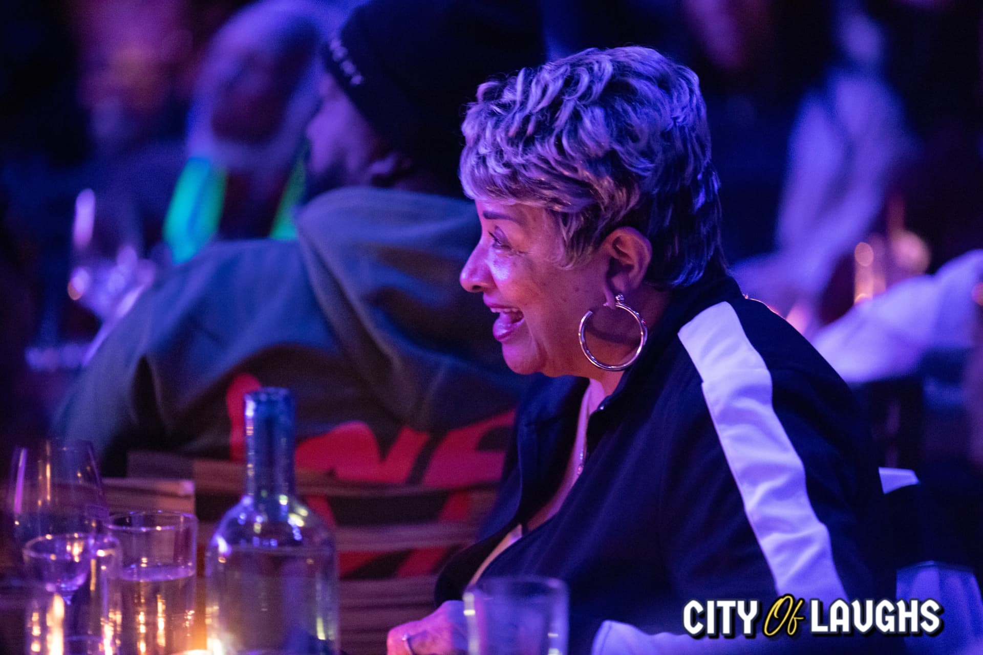 Woman with hoop earrings laughing in the audience
